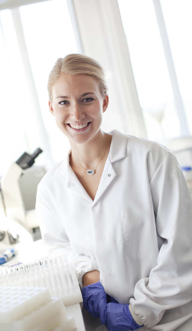 doctor in training in a labcoat smiling at the camera