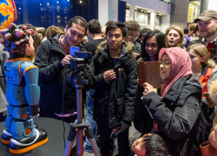 Members of the public engage with a robot at an Imperial Fringe event