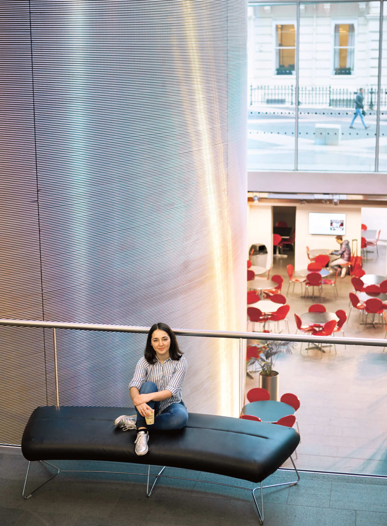 Imperial student Elisabeth Mahase sitting on a bench near the Business School Cafe