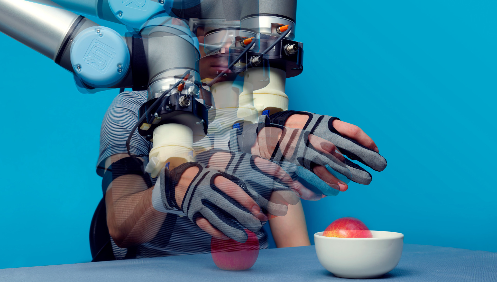 Soft robotic glove interface assists a person to move an apple from a table into a bowl