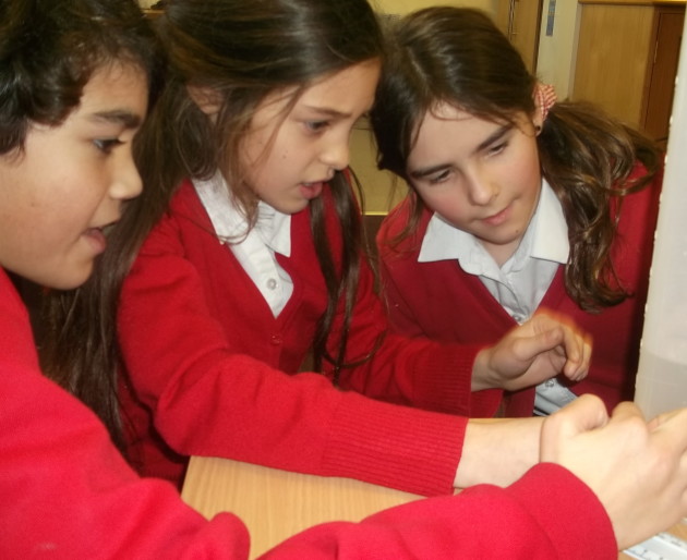 School students looking at water in a measuring cylinder