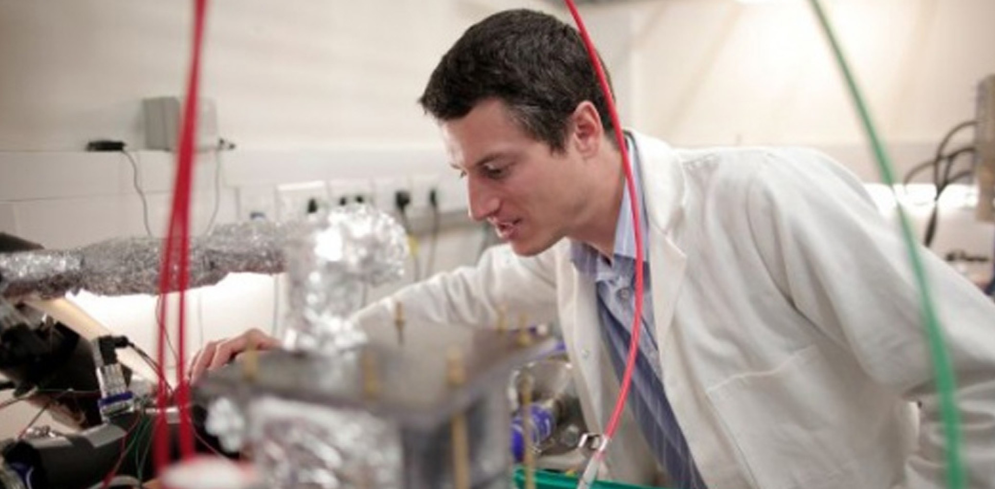  Dr Gregory Offer working in a lab surrounded by pipes and wires