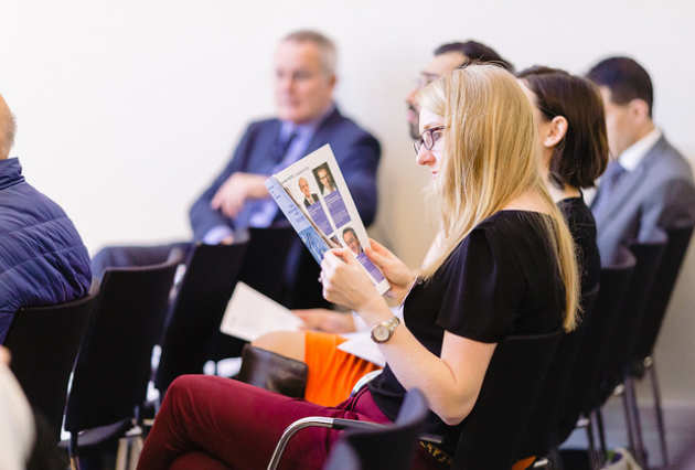 A woman reading the symposium agenda