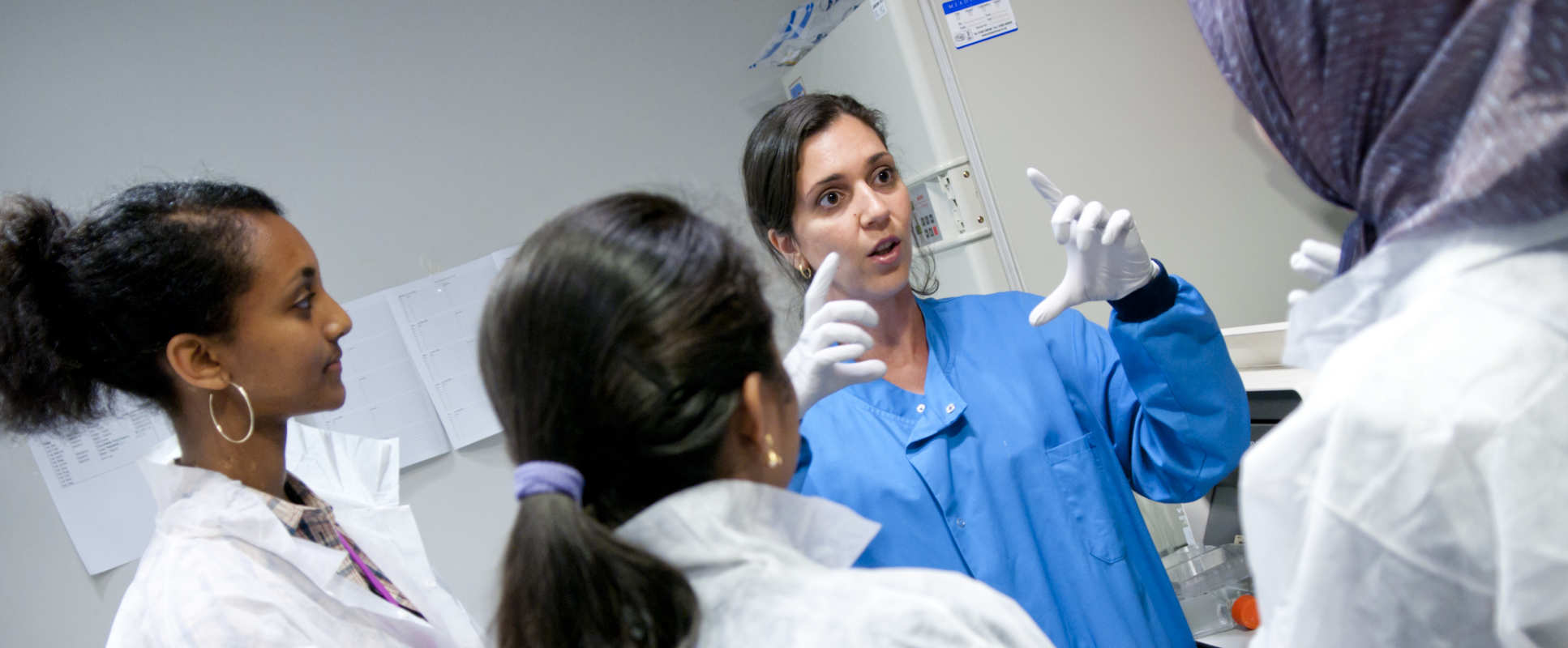 Female researcher talks to colleagues in lab