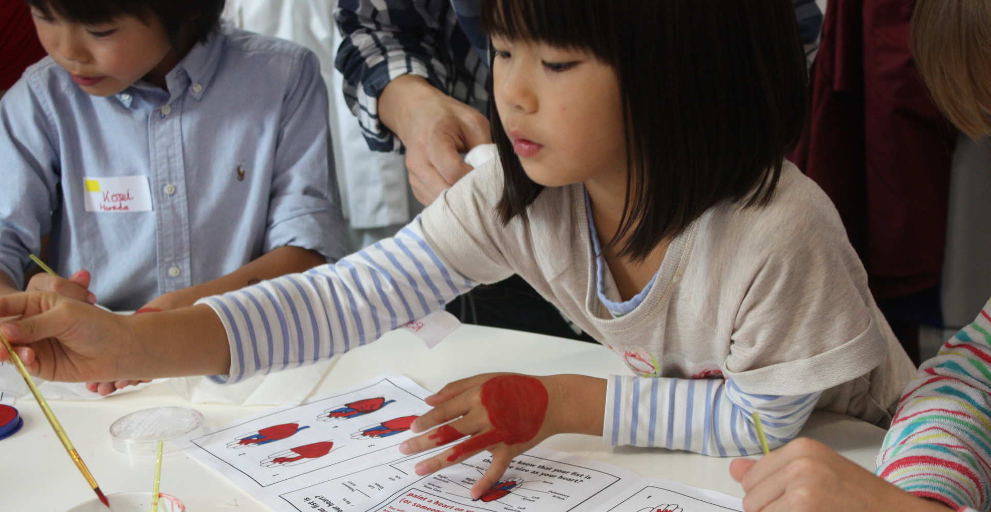 Young girl paints hand