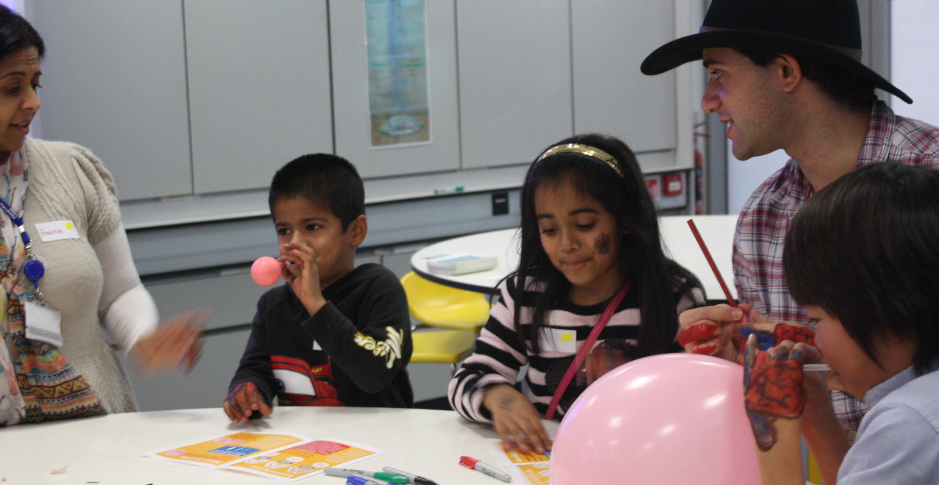 Adults and kids at table with pen markers