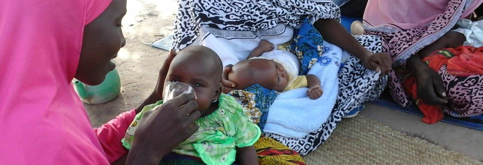 A mother giving gas to a young child in Africa