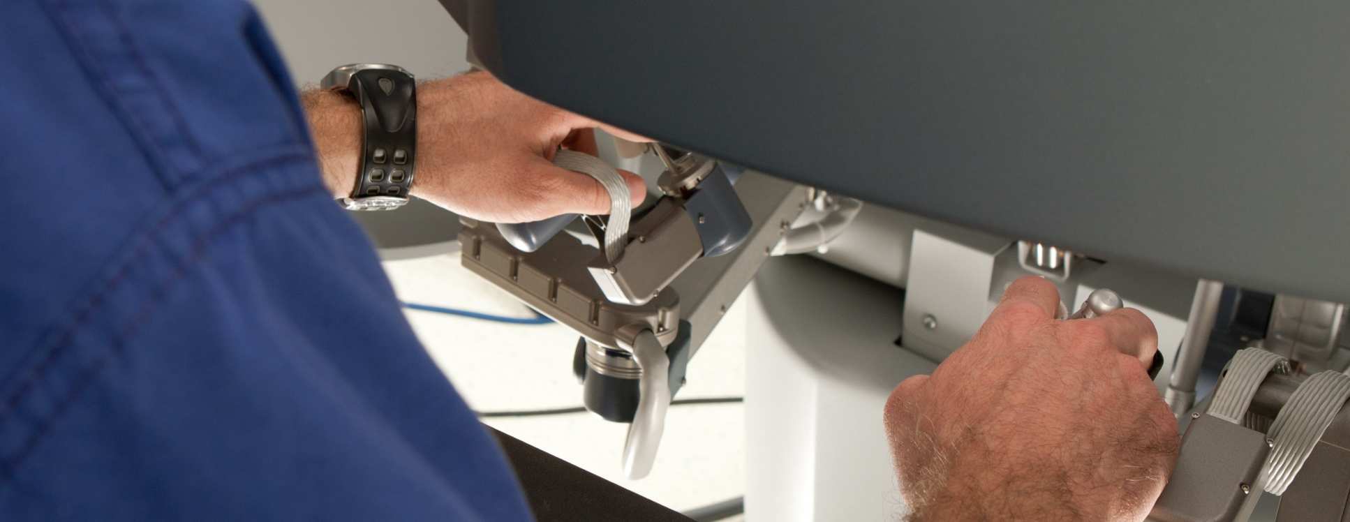 Hands operating a robotic surgery machine. 