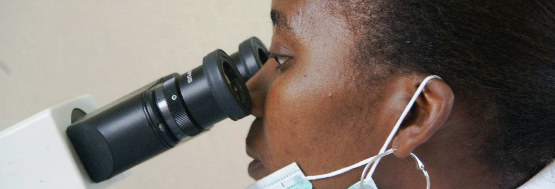 A member of research staff looking through a microscope