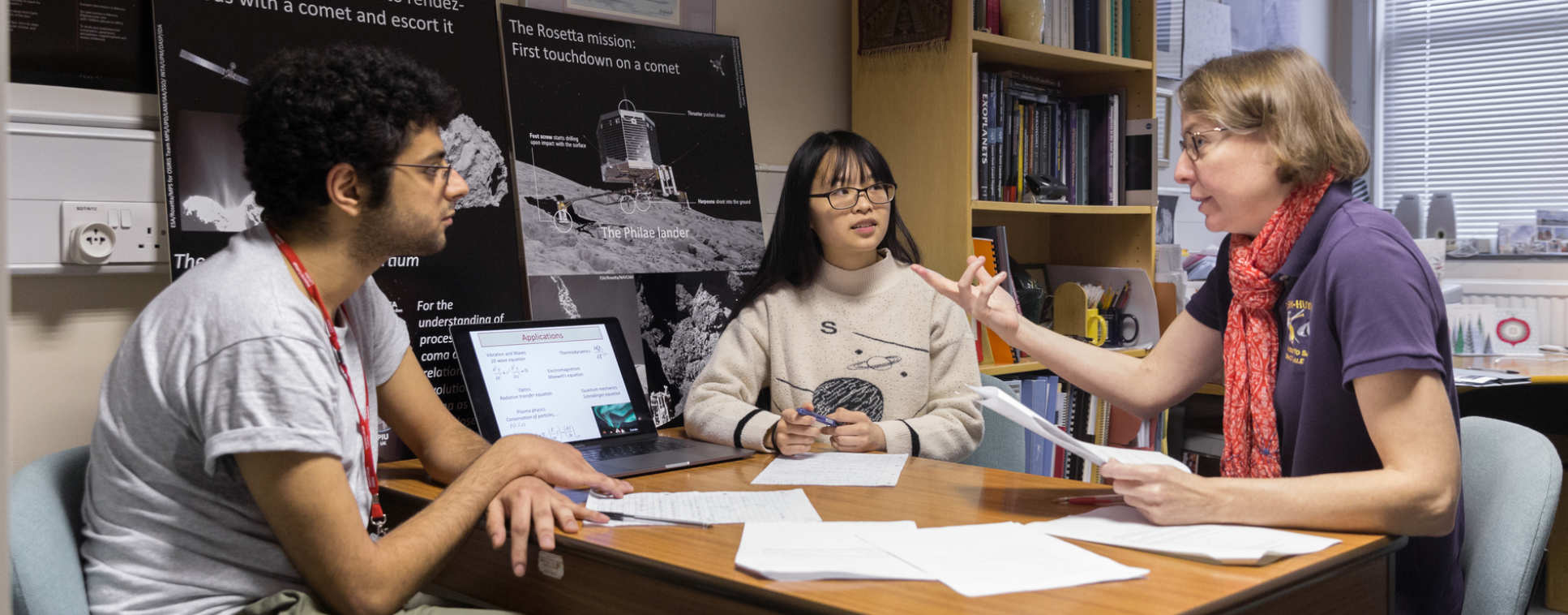 Two students in discussion with their tutor