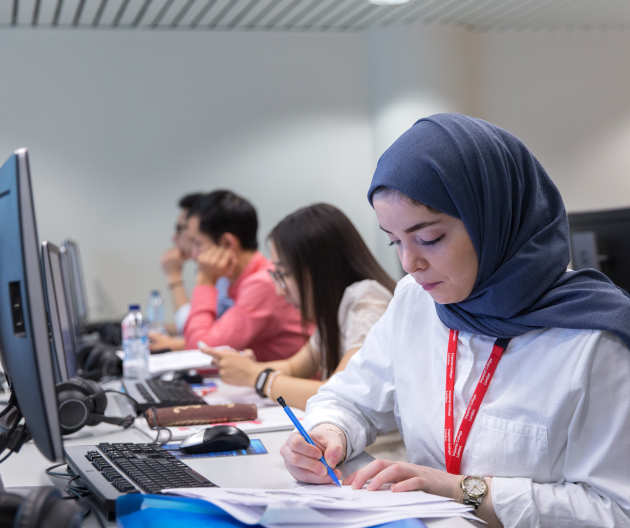 Student writing at a desk