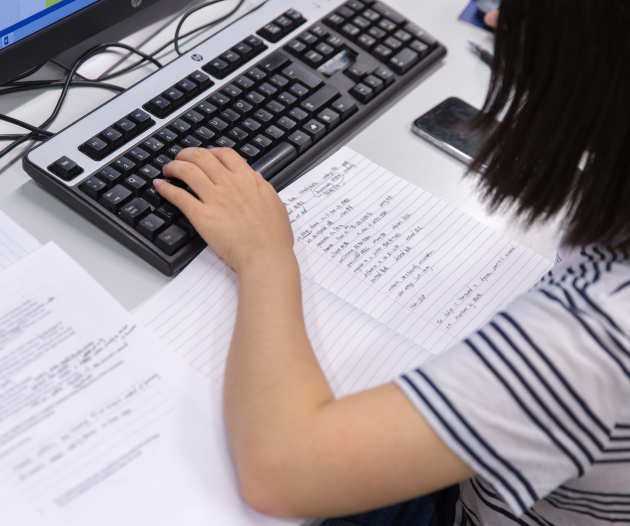 student making notes from a computer