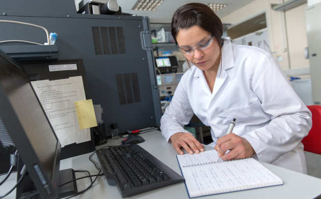 student making notes from a computer