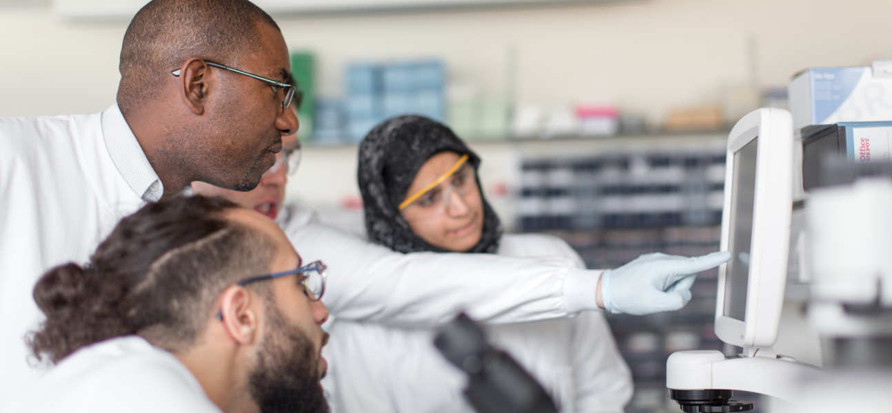 Lecturer assists students with lab equipment