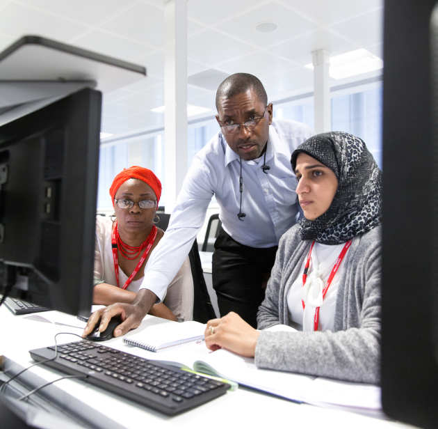 Tutor working with two students at a computer