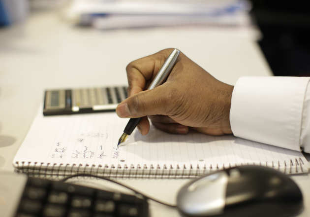 Man writing with a pen and paper