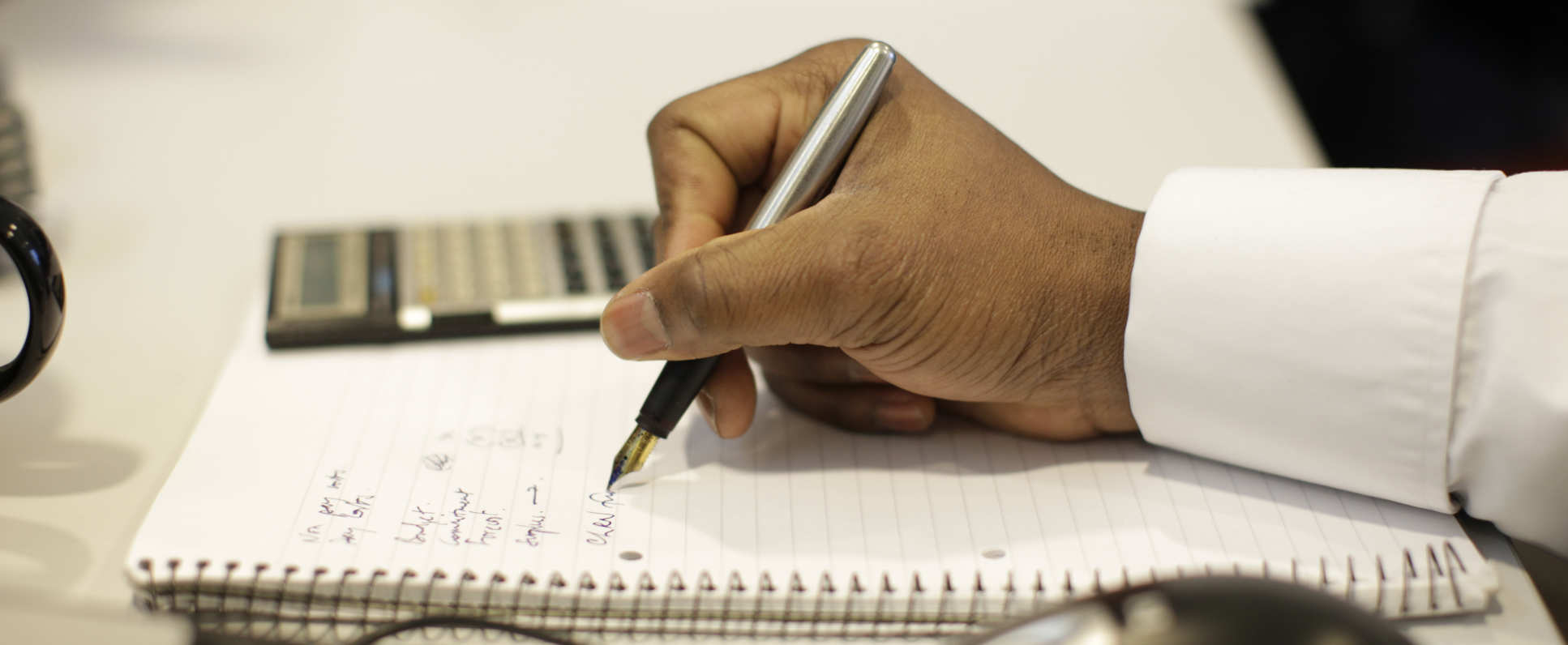 Someone taking notes at a desk