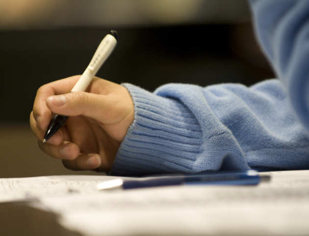 Student writing on a notepad