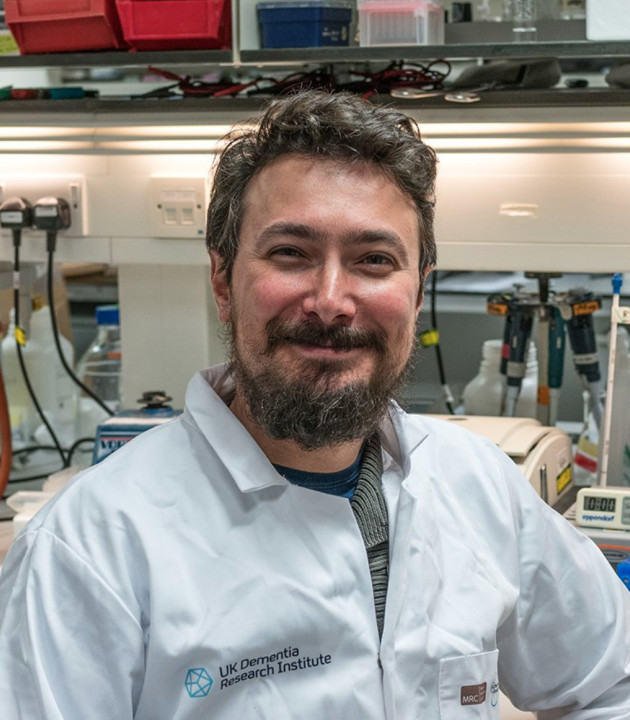 Headshot of man in lab coat smiling