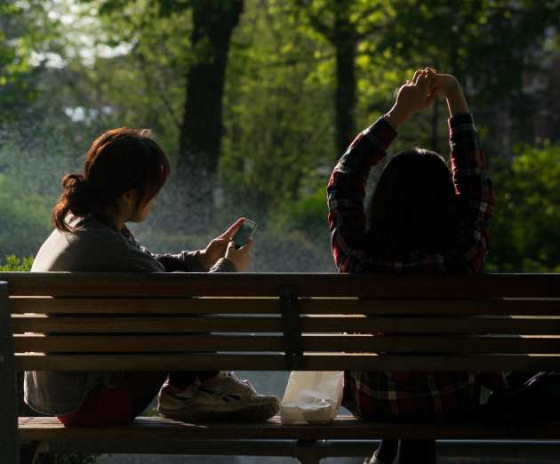 Two people sat apart on a bench